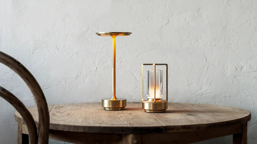 Two table lamps on a wooden table with a white textured wall background