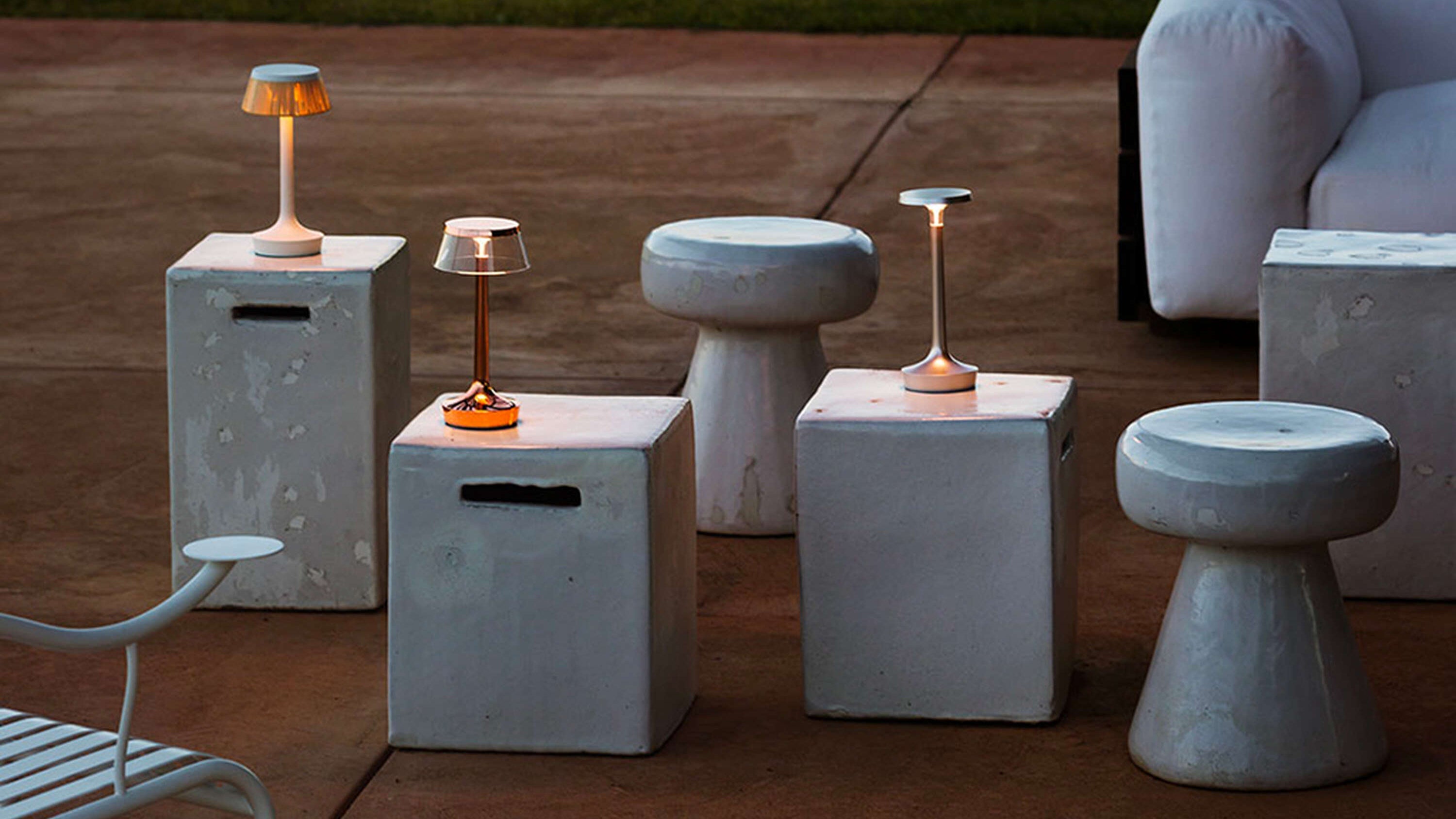 Concrete side tables and stools with lamps on a patio