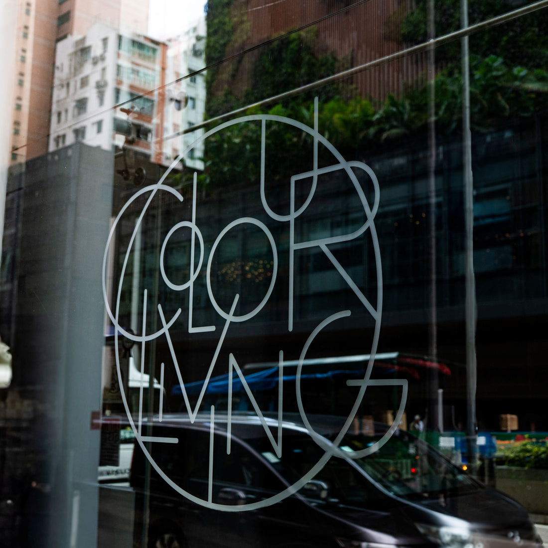 Glass door with 'Colorliving' logo in an urban setting